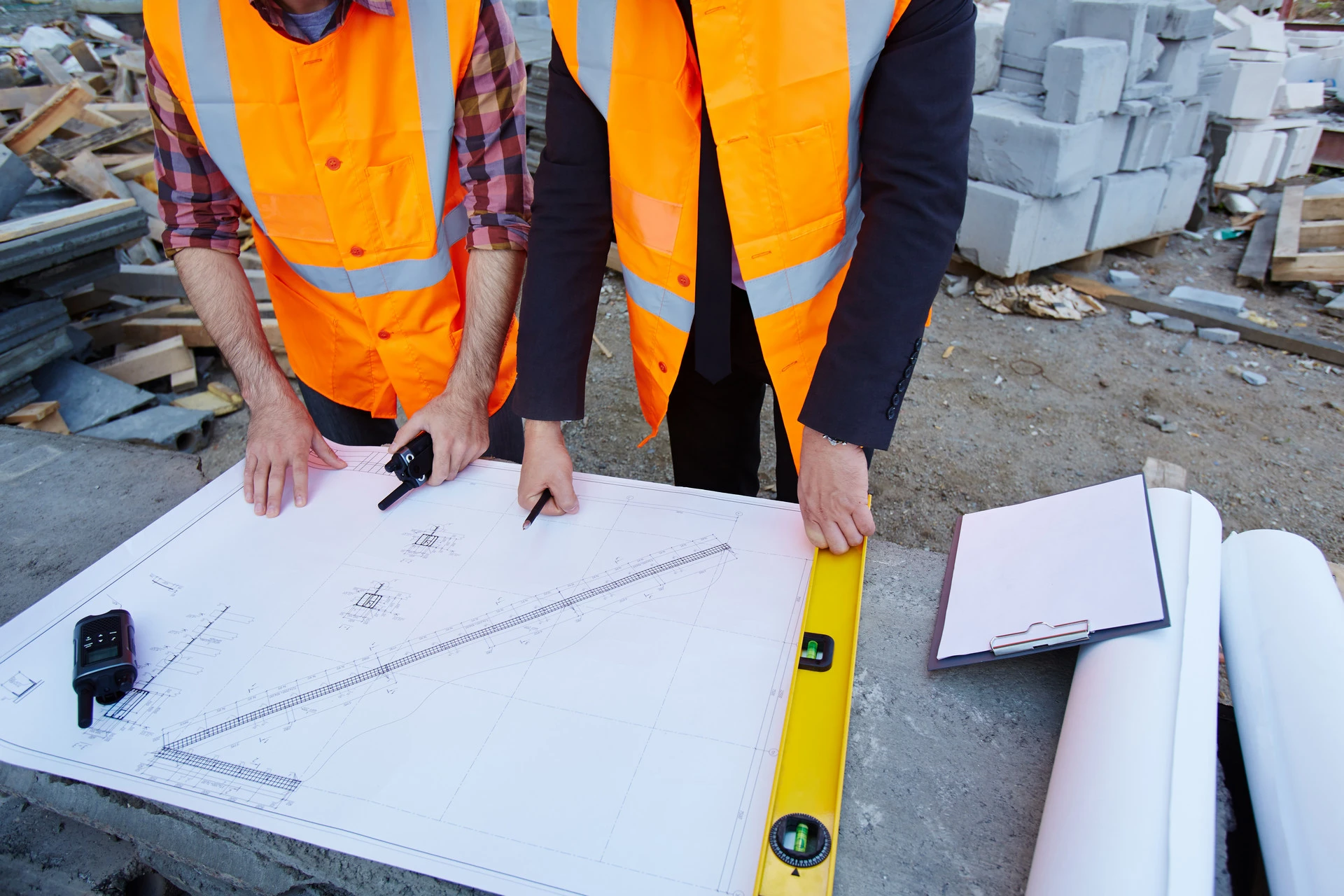 Two builders examine construction drawings.